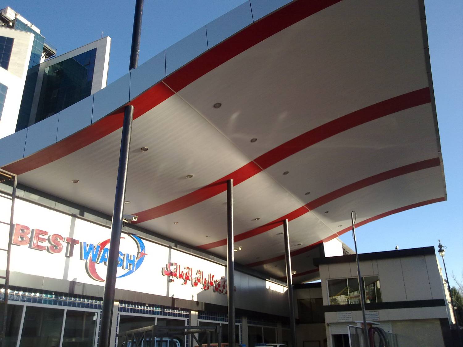 Completed canopy from below — ACP soffit with red stripe and recessed lights