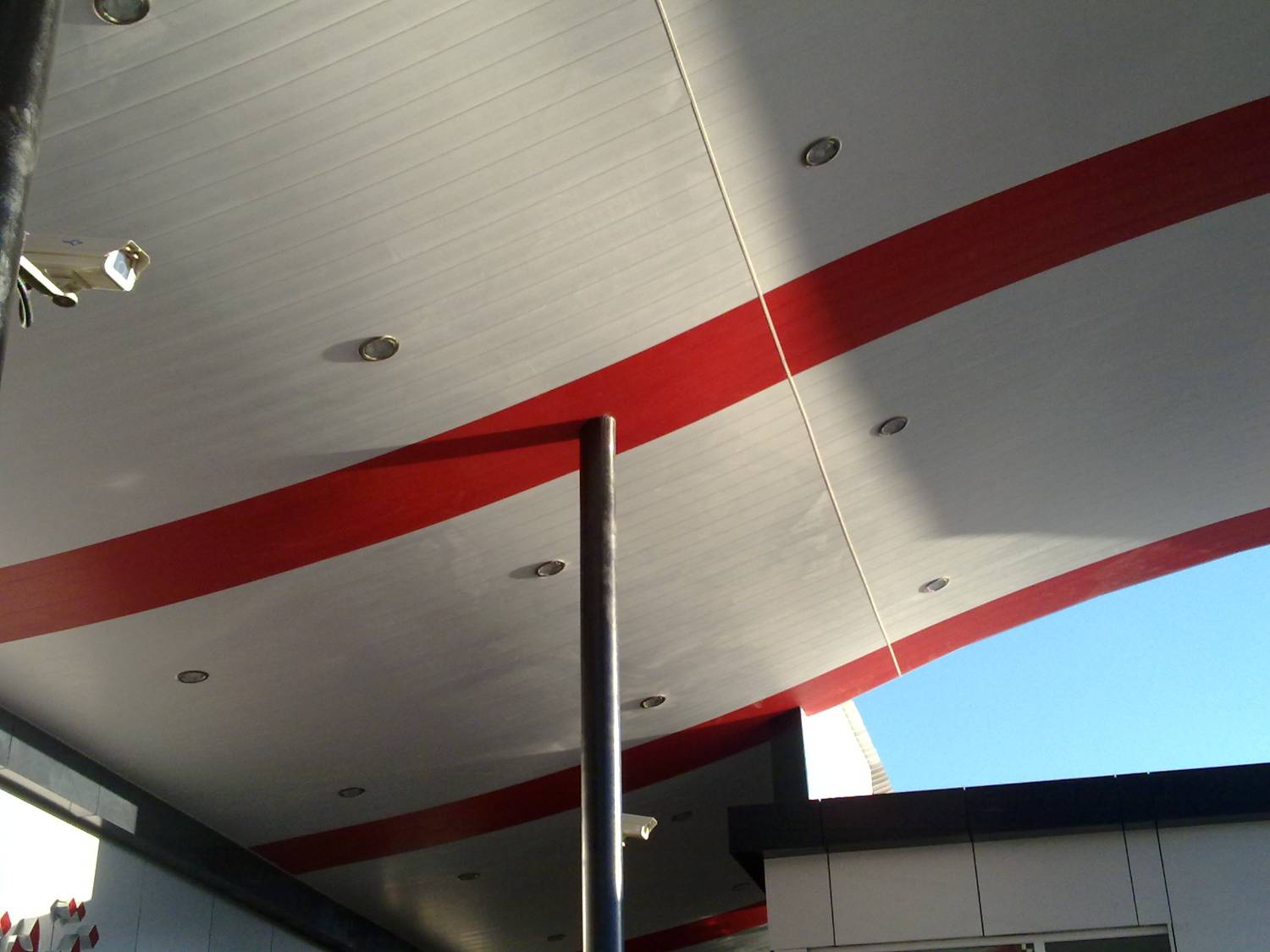 Soffit detail — curved ACP panels with red accent band and downlights