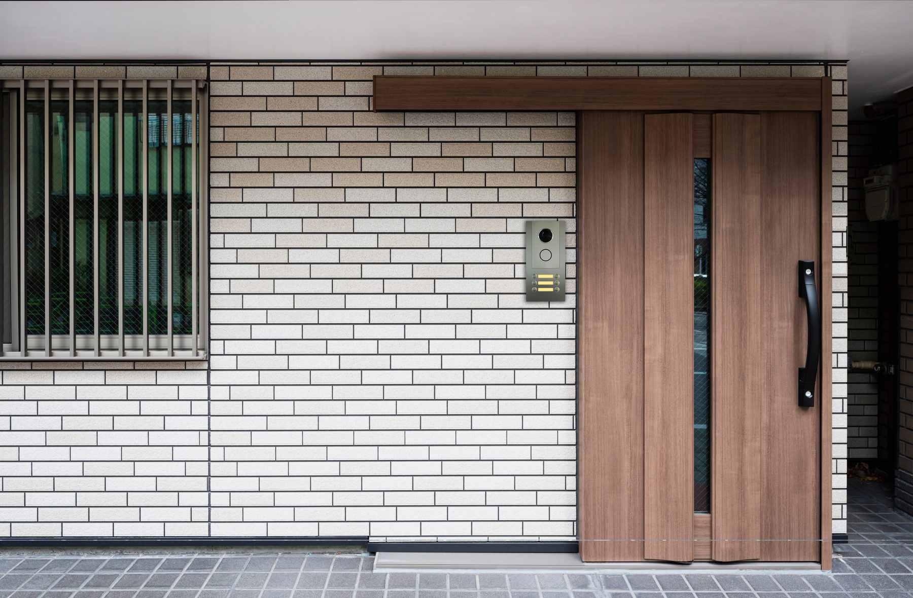 Installed panel, lobby with rendered concrete and brick wall, wooden sliding door