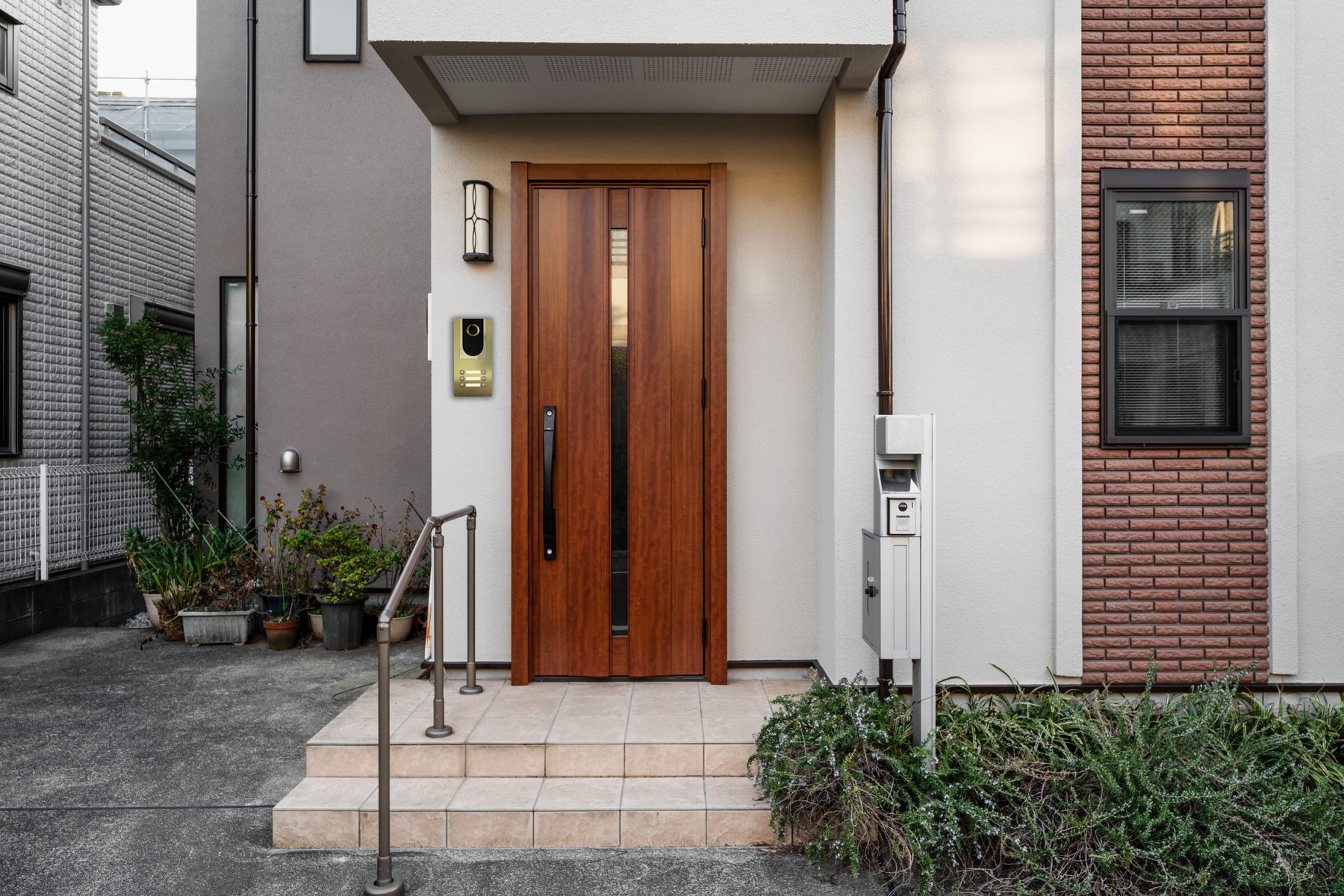 Installed panel, gold finish, on a wooden gate beside a Japanese residential entrance